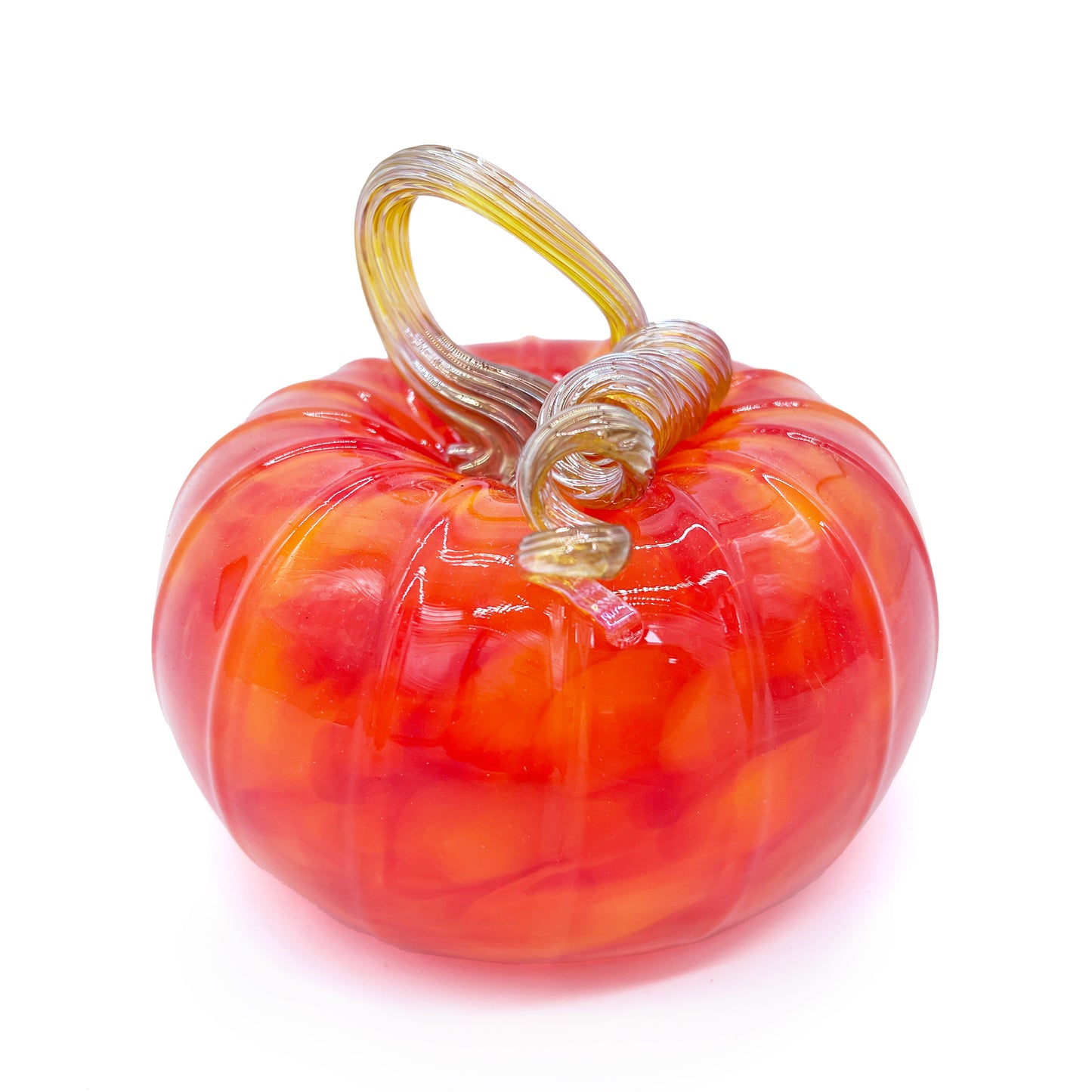 A handblown glass pumpkin against a white background