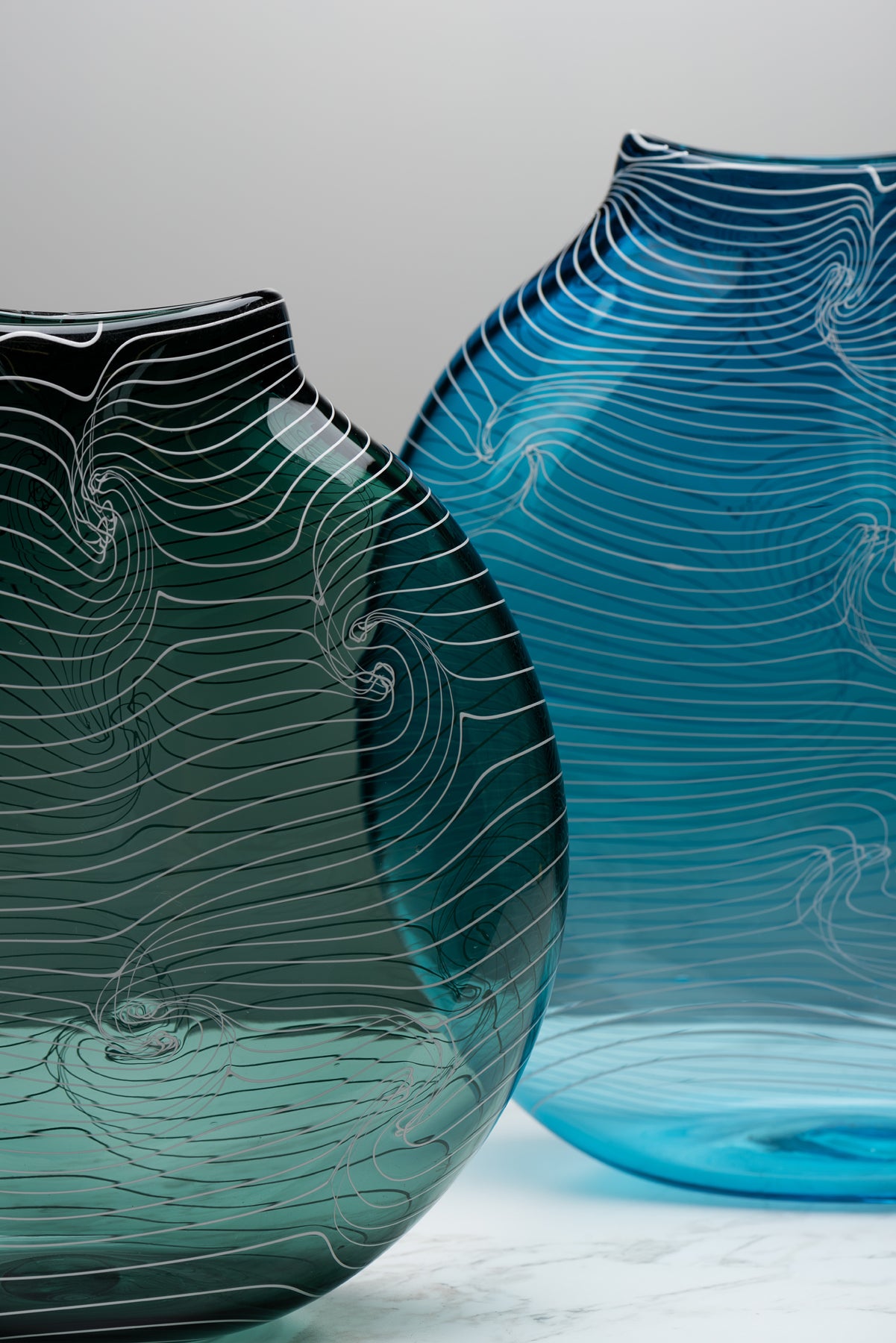 A detail view of two overlapping blue handblown vessels by Asher Holman (small batch glass). Image by Loam